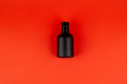 Darmowe zdjęcie z galerii z butelka perfum, czerwone tło, makieta