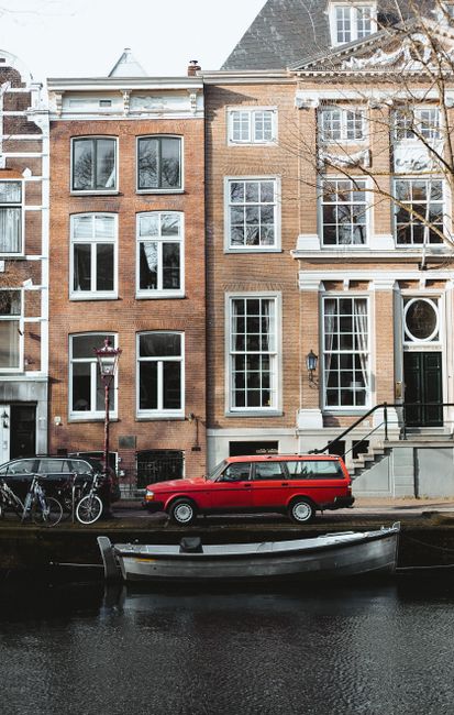 Exterior of aged brick residential house with large windows located on city waterfront near cars