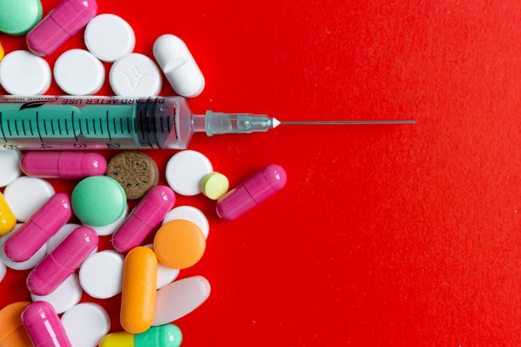 Close-Up Shot Of Pills And A Syringe