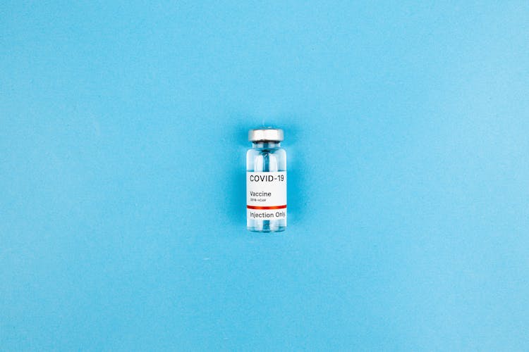 Covid Vaccine Bottle On Blue Background