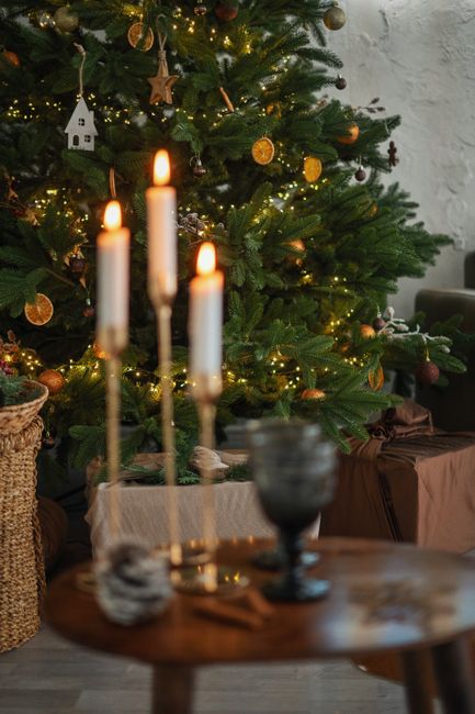 A festive Christmas tree decorated with lights and candles creating a cozy holiday atmosphere.