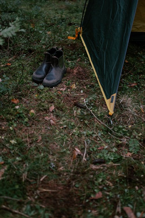 Boots Near Green and Yellow Tent on Green Grass