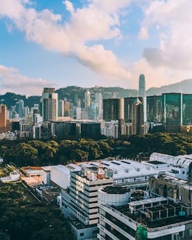 A vibrant cityscape showcasing Hong Kong Island's skyline with iconic skyscrapers and lush greenery.