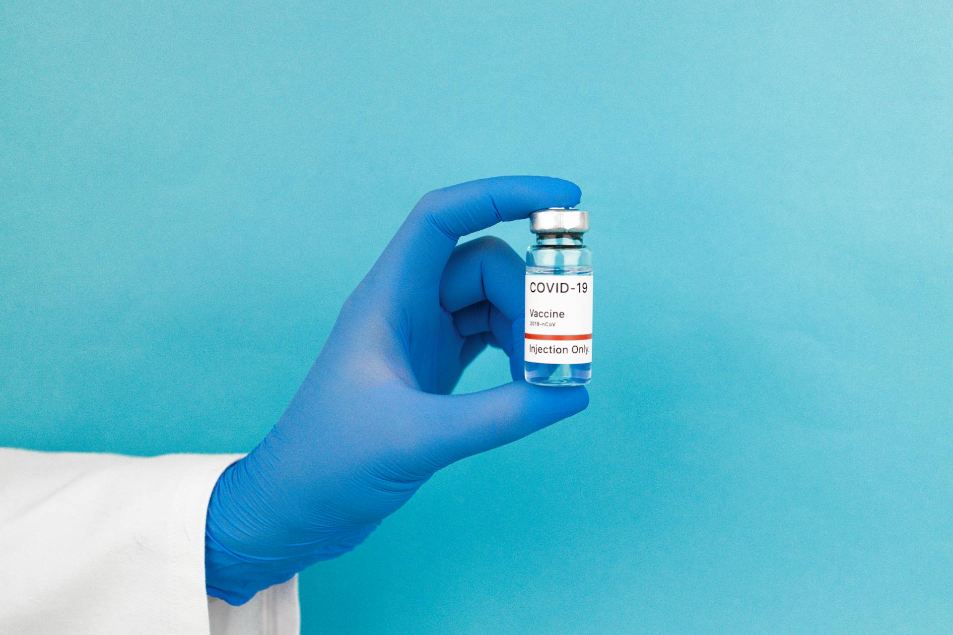 Person Holding White Labeled Bottle