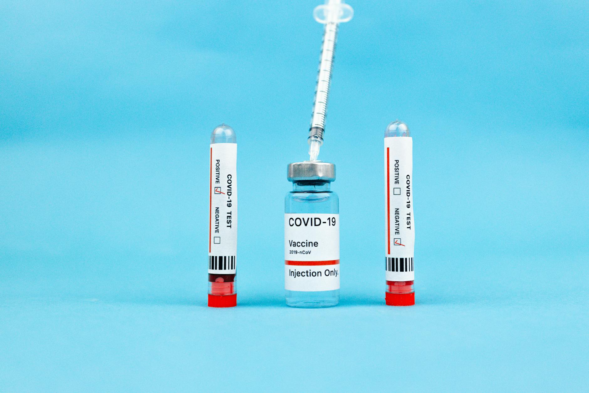 Vaccine Ampoule and Test Tubes on Blue Surface