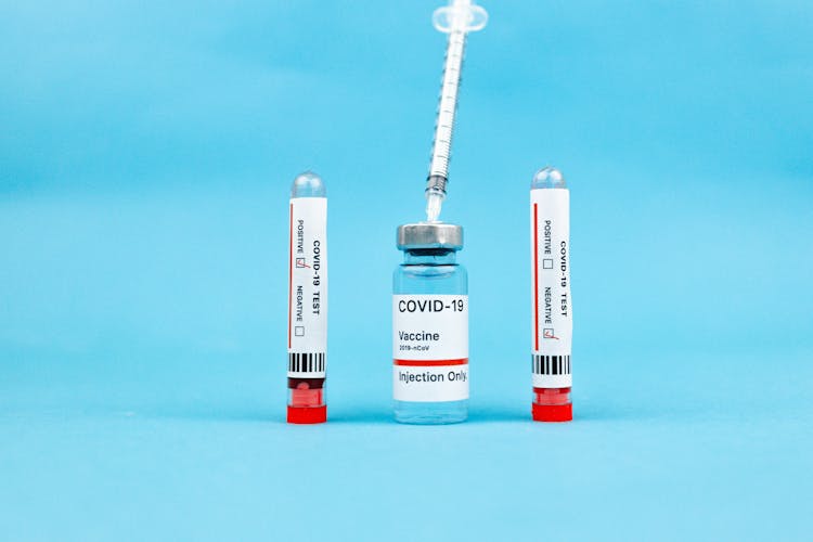 Vaccine Ampoule And Test Tubes On Blue Surface