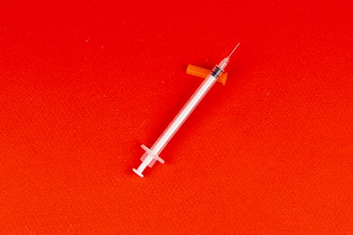 Syringe on a Red Surface