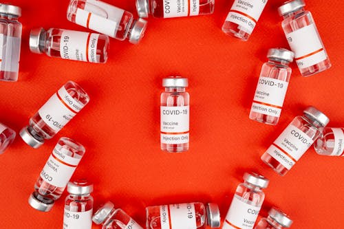 Free Vaccine Vials on a Red Surface Stock Photo