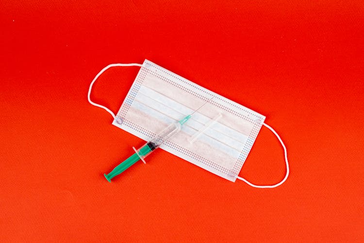 Syringe With Needle On White Face Mask