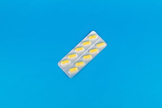 Pack of yellow capsules on a vibrant blue background symbolizing modern medicine.