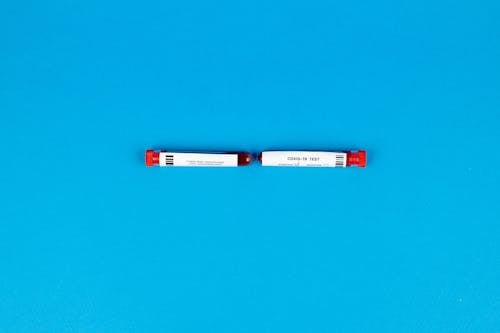 Medical Test Tubes with Blood Sample and Label on Blue Background