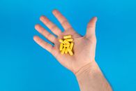 Person Holding Yellow Plastic Beads