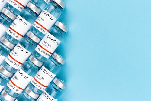 

A Close-Up Shot of Covid-19 Vaccine Vials on a Blue Surface