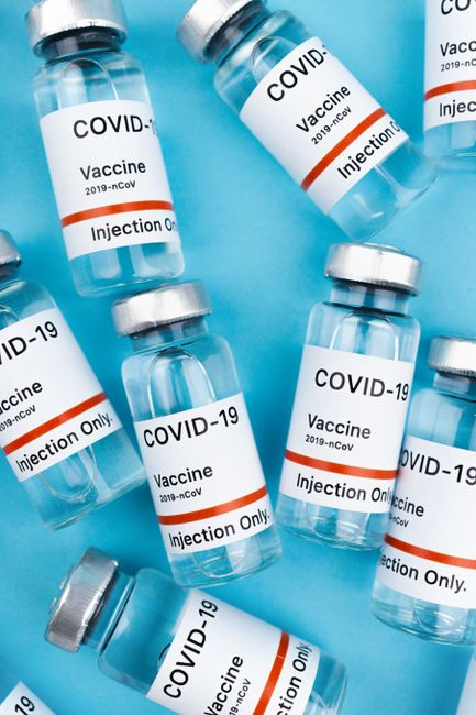 Vaccine vials for COVID-19 on a blue background, symbolizing pandemic efforts.