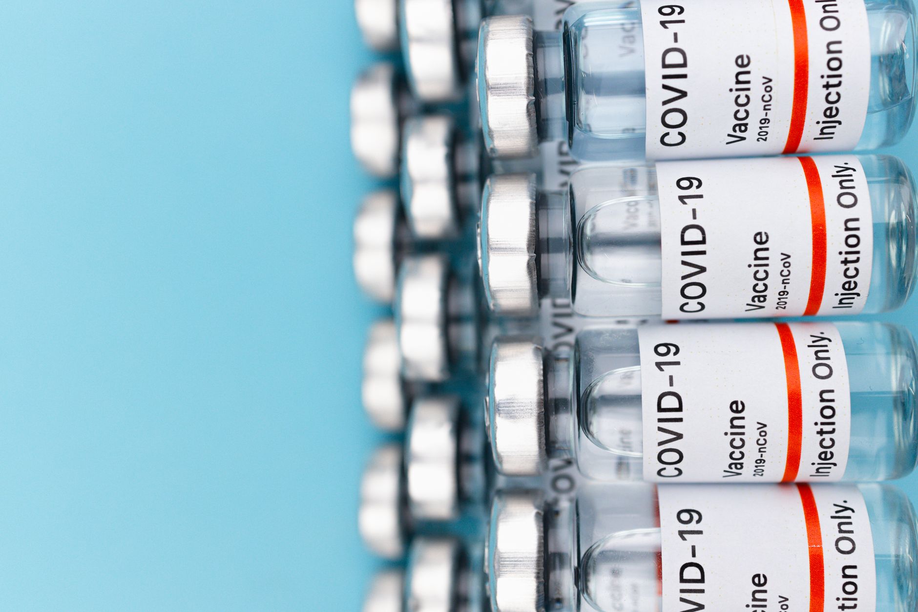 Close-up of COVID-19 vaccine vials arranged on a blue background, highlighting medical innovation.