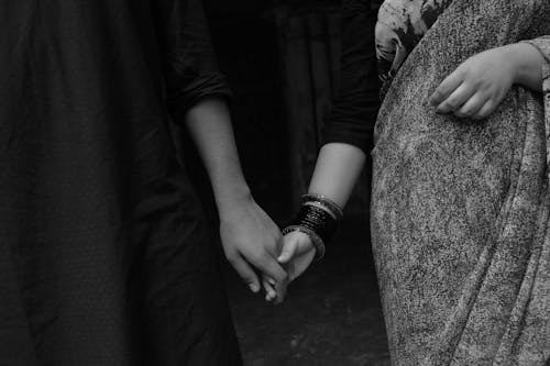 Grayscale Photo of Couple Holding Each Others Hand