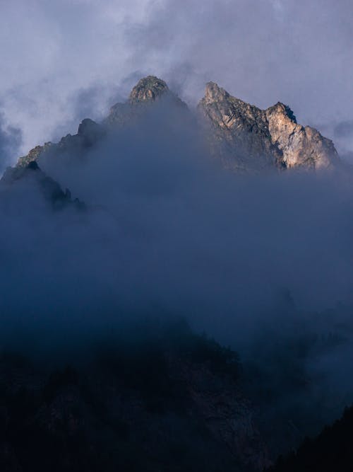 Free Rocky Mountain Peak Covered with Clouds Stock Photo