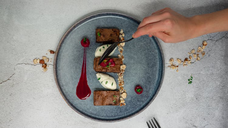 Crop Person Eating Brownie With Ice Cream