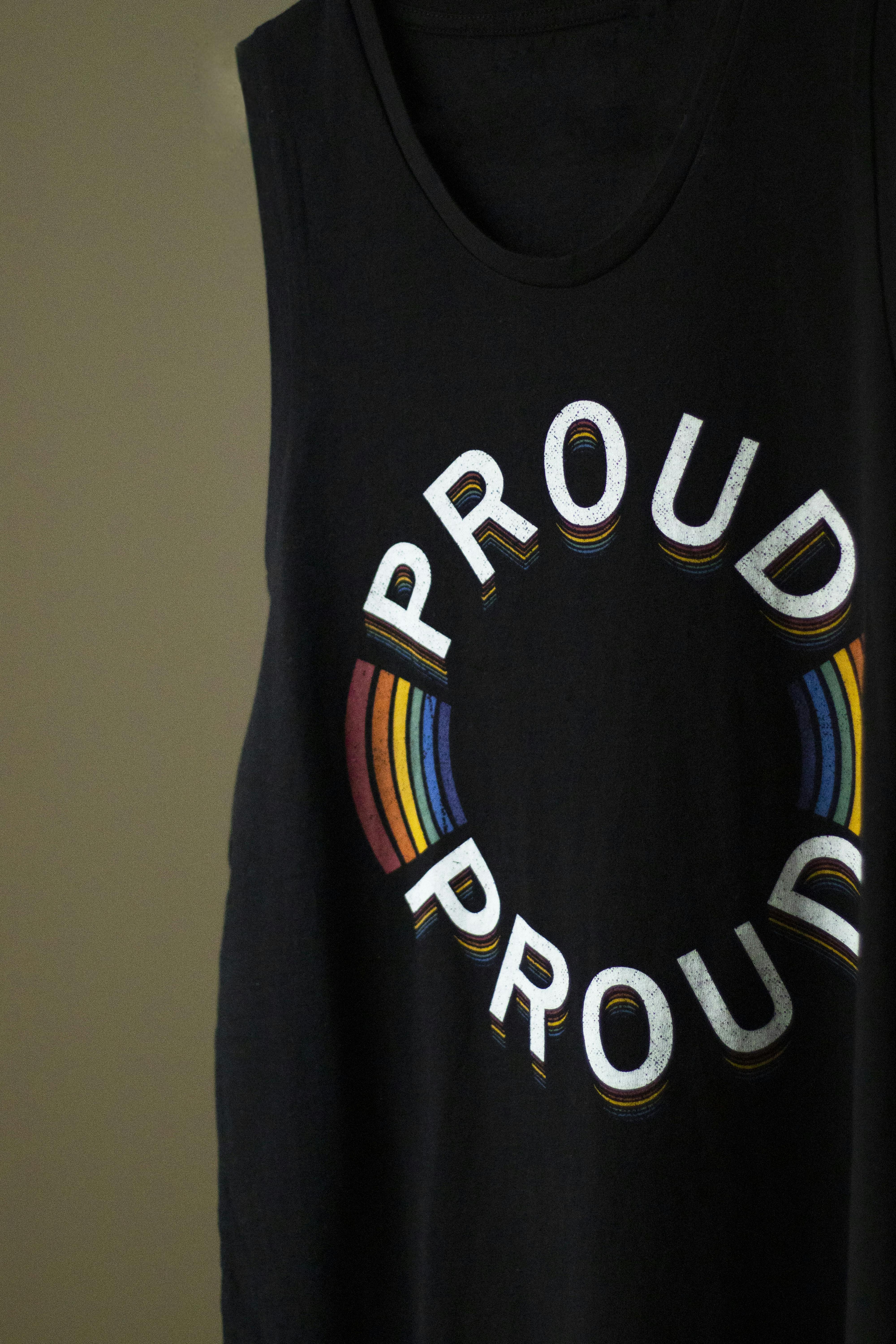 Close-up of a black tank top with a rainbow 'Proud' design symbolizing LGBTQ+ pride.