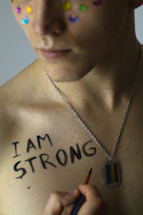 Free Close-up of person with 'I Am Strong' on chest and rainbow-themed necklace. Stock Photo