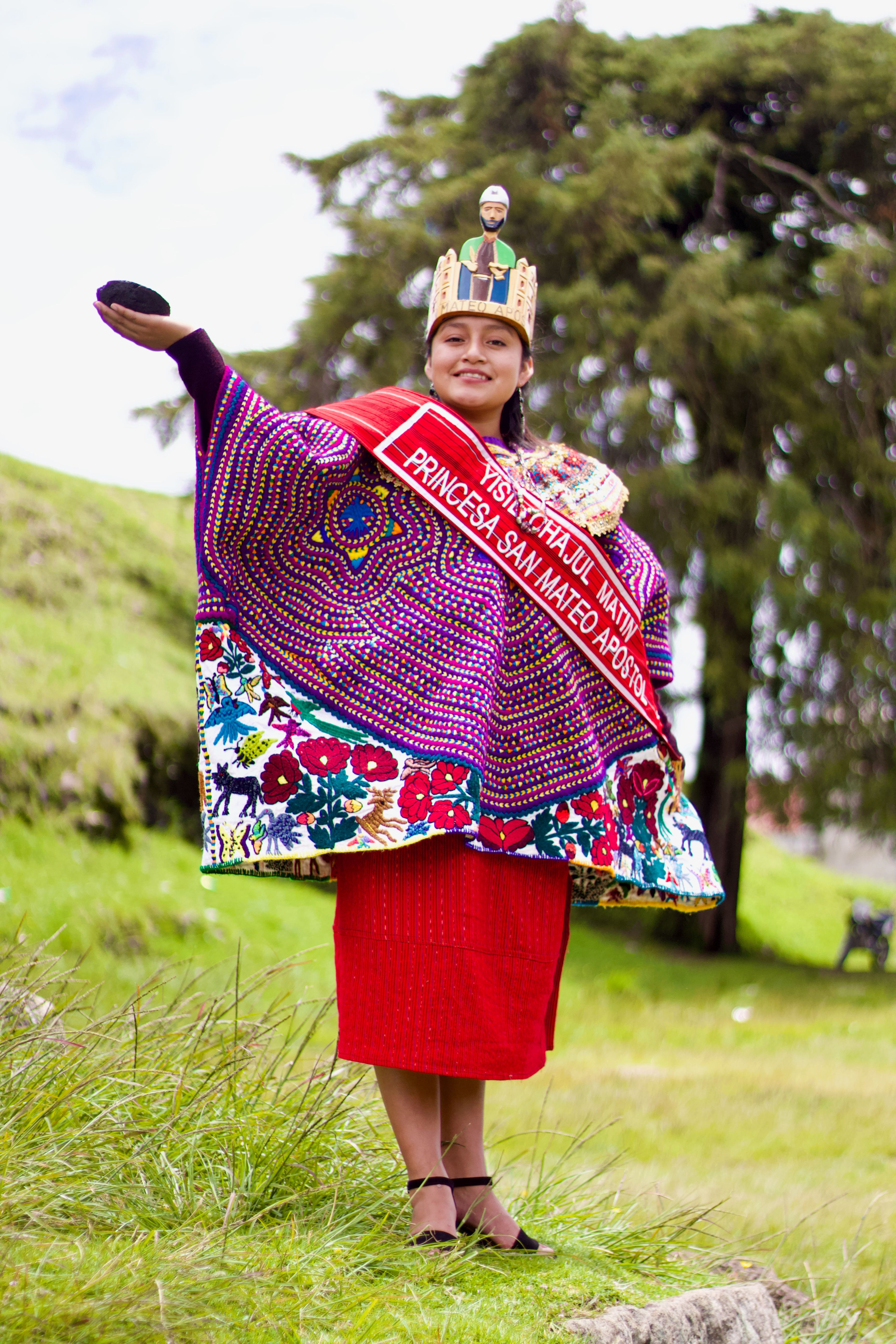 A young woman in vibrant traditional attire at a cultural festival, exuding pride and joy.