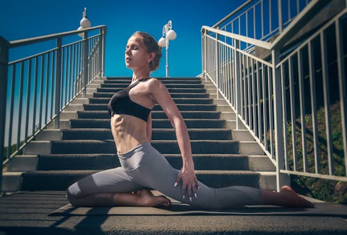 Young female doing yoga on staircase