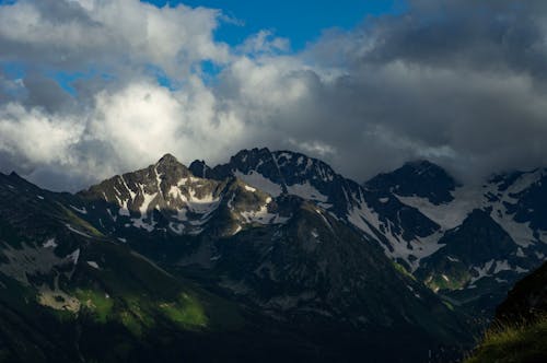 Snow Covered Mountain Under the Cloudy Sky