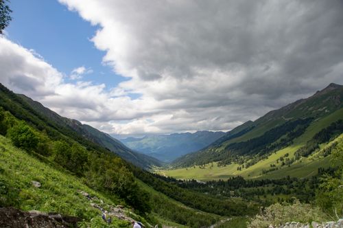 Free Scenic mountain valley with lush greenery and cloudy sky, perfect for hiking and nature lovers. Stock Photo