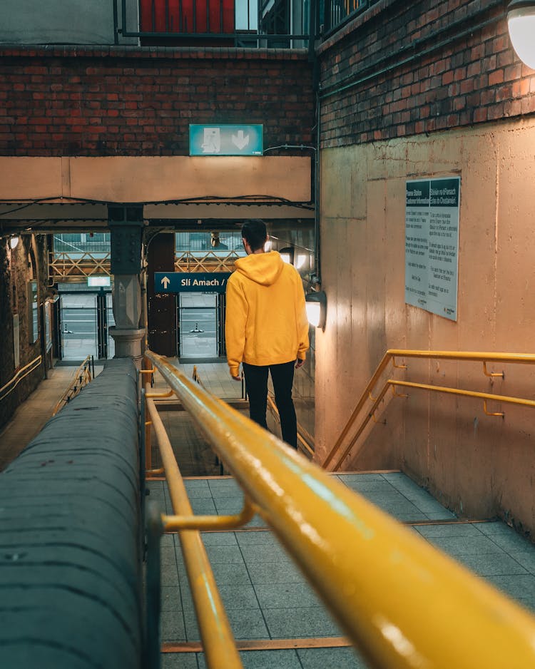  Man In Yellow Hoody Walking Down The Stairs