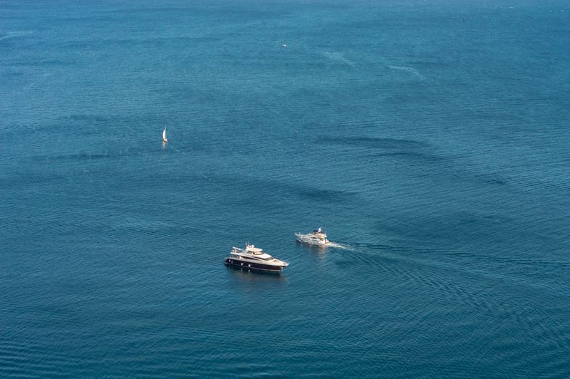 Aerial view of a luxury yacht and sailboat navigating the Pacific Northwest
