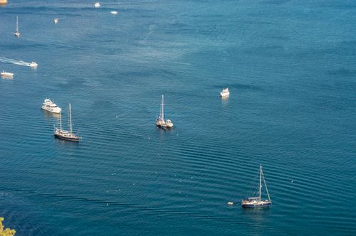Free A serene aerial view of sailboats and yachts floating on blue waters, perfect for leisure and recreation. Stock Photo