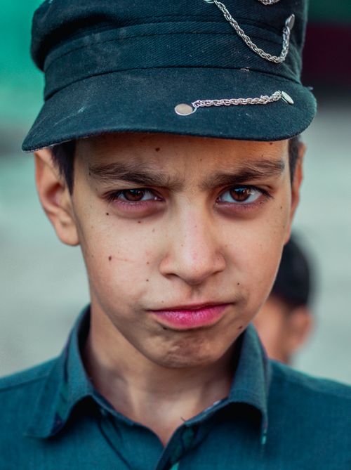 Free Close-up portrait of a teenage boy wearing a cap with a serious expression outdoors. Stock Photo
