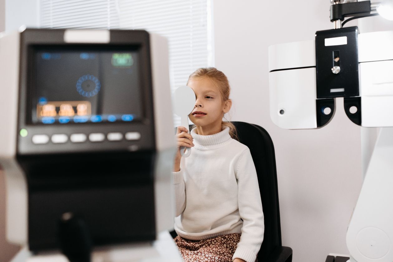 Young girl undergoing a vision screening test with an eye covered