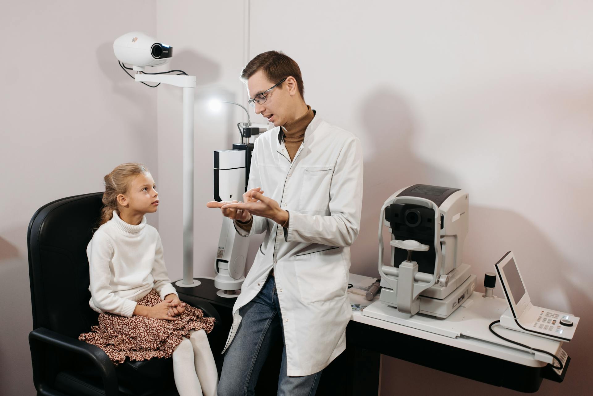 Ophthalmologist consulting young patient in medical clinic.