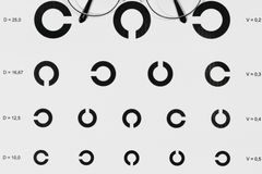 Close-up of an eye examination chart with eyeglasses on top, highlighting vision testing.