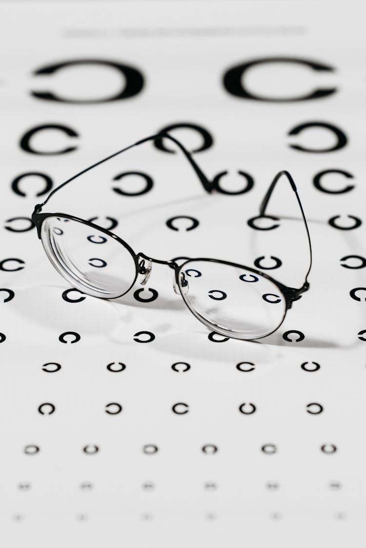 Black Framed Eyeglasses On White Paper With Printed Pattern