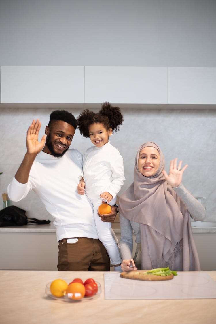 Happy Multiethnic Family Waving Hands At Camera