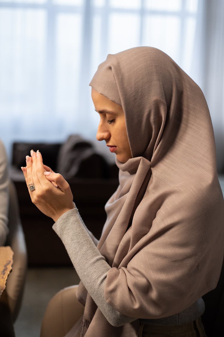 Muslim Woman With Closed Eyes Praying At Table