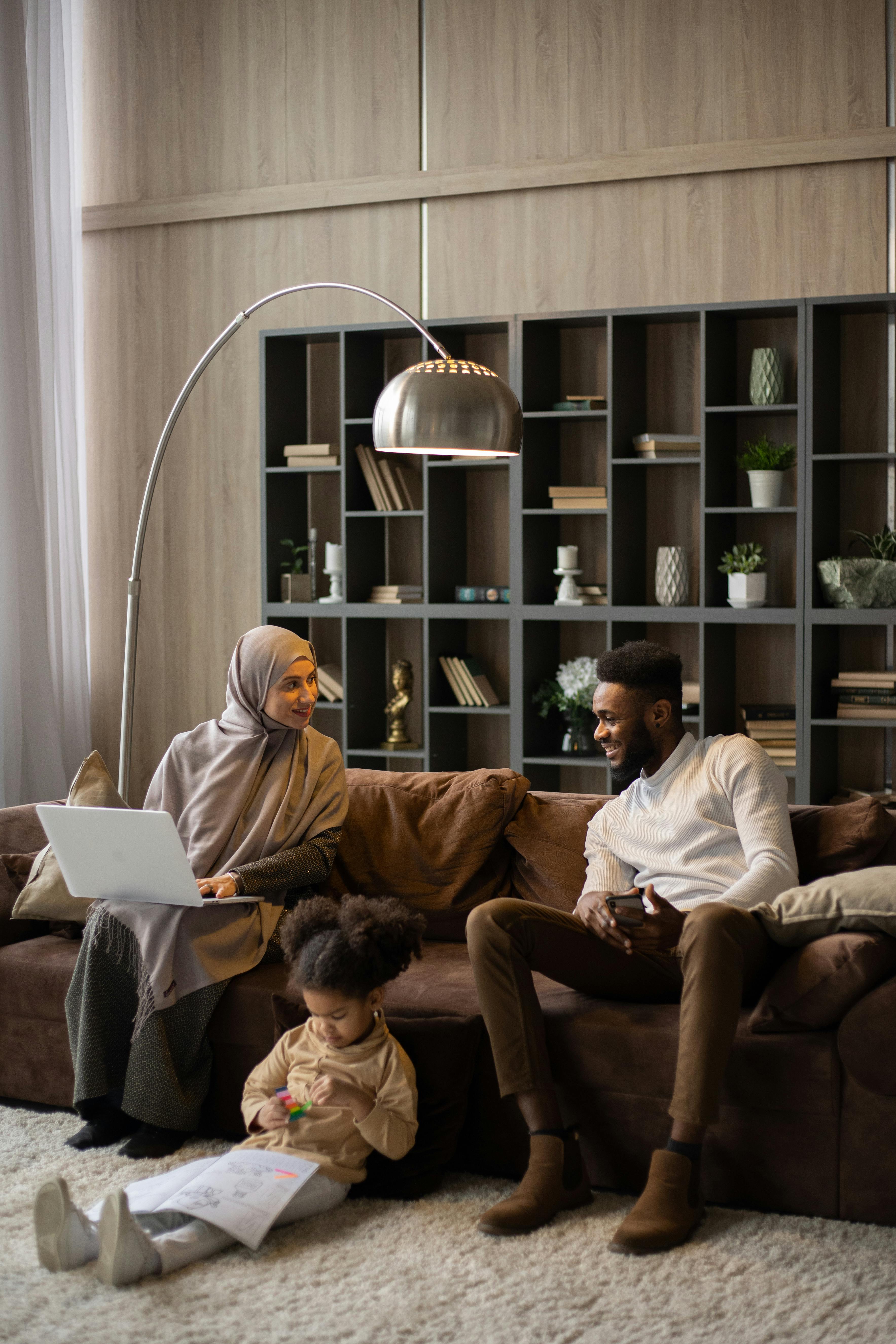 smiling couple with little girl in light room