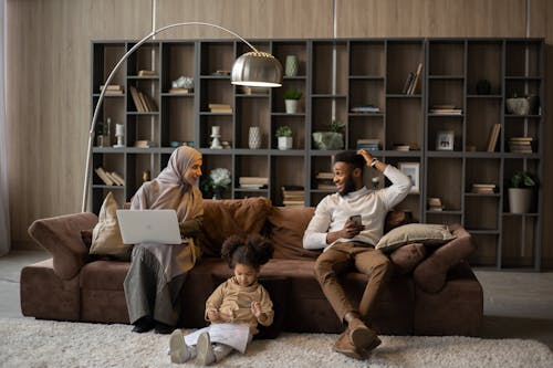 Glad ethnic family with laptop and smartphone