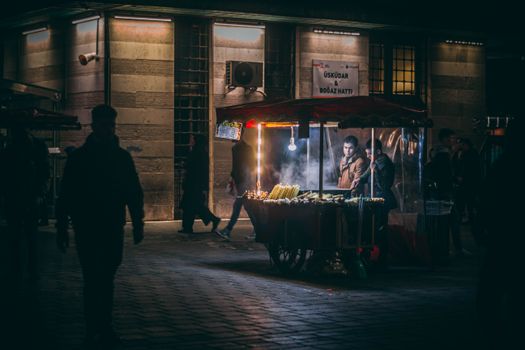 Nighttime street food scene in Istanbul with a chestnut vendor and lively atmosphere.