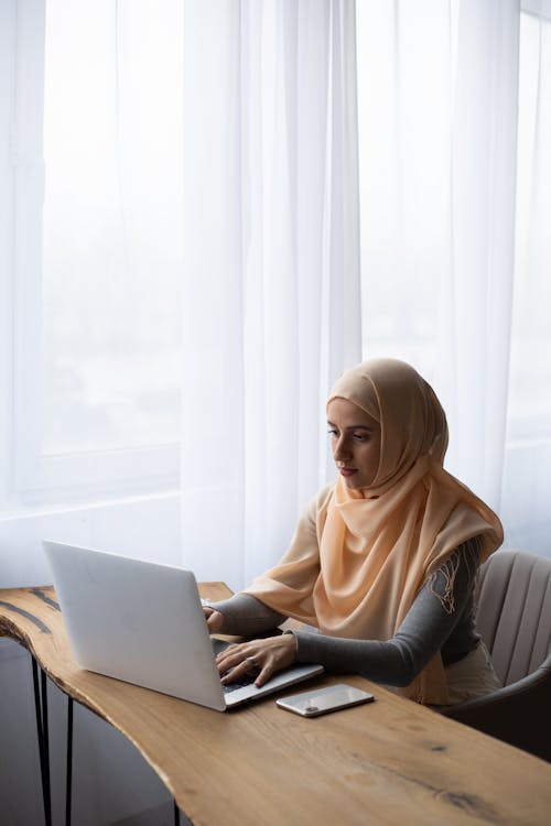 Free Calm ethnic woman with laptop during work Stock Photo