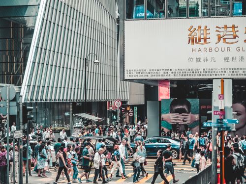 Free Crowd of people crossing street in busy Hong Kong shopping district under large signs. Stock Photo