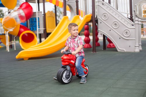 A Young Boy Riding a Motorcycle Toy