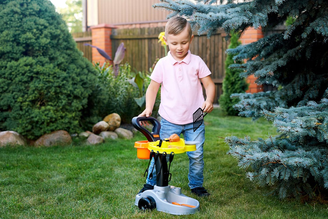 Free A Boy in the Garden Playing with Barbecue Toy Stock Photo