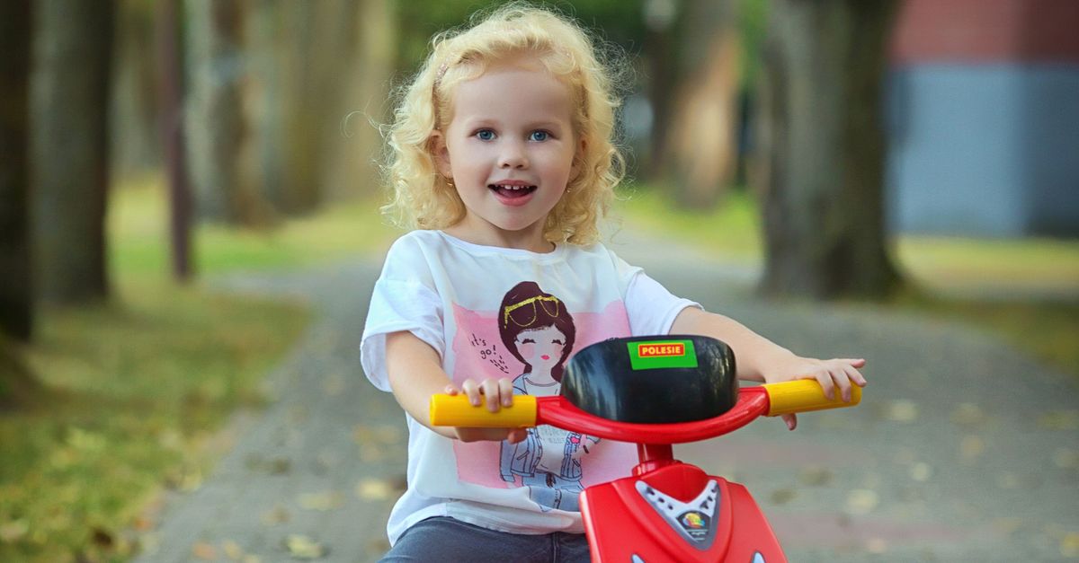 Girl Riding Red Scooter on Pavement with Chalk Drawings · Free Stock Photo
