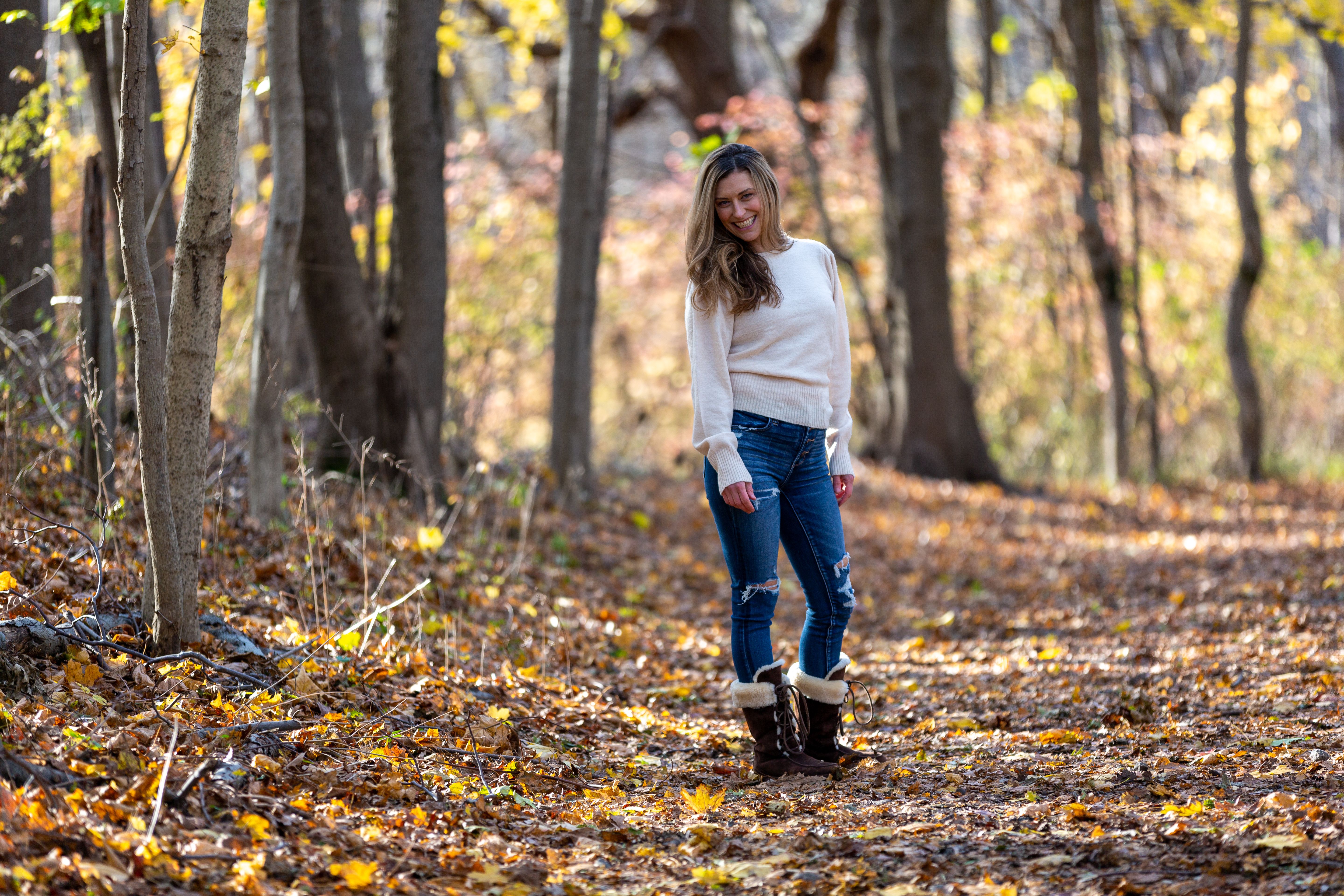 Cheerful woman standing in autumn forest · Free Stock Photo