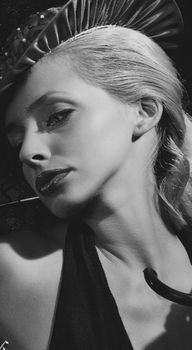 A stunning black and white portrait capturing an elegant woman with a hat and pensive expression.