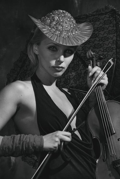 Woman in Black Tank Top and Hat with Flowers Holding Violin 