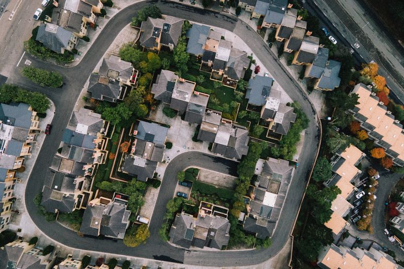 Aerial view of a modern neighborhood with roads and buildings in a lush urban setting.